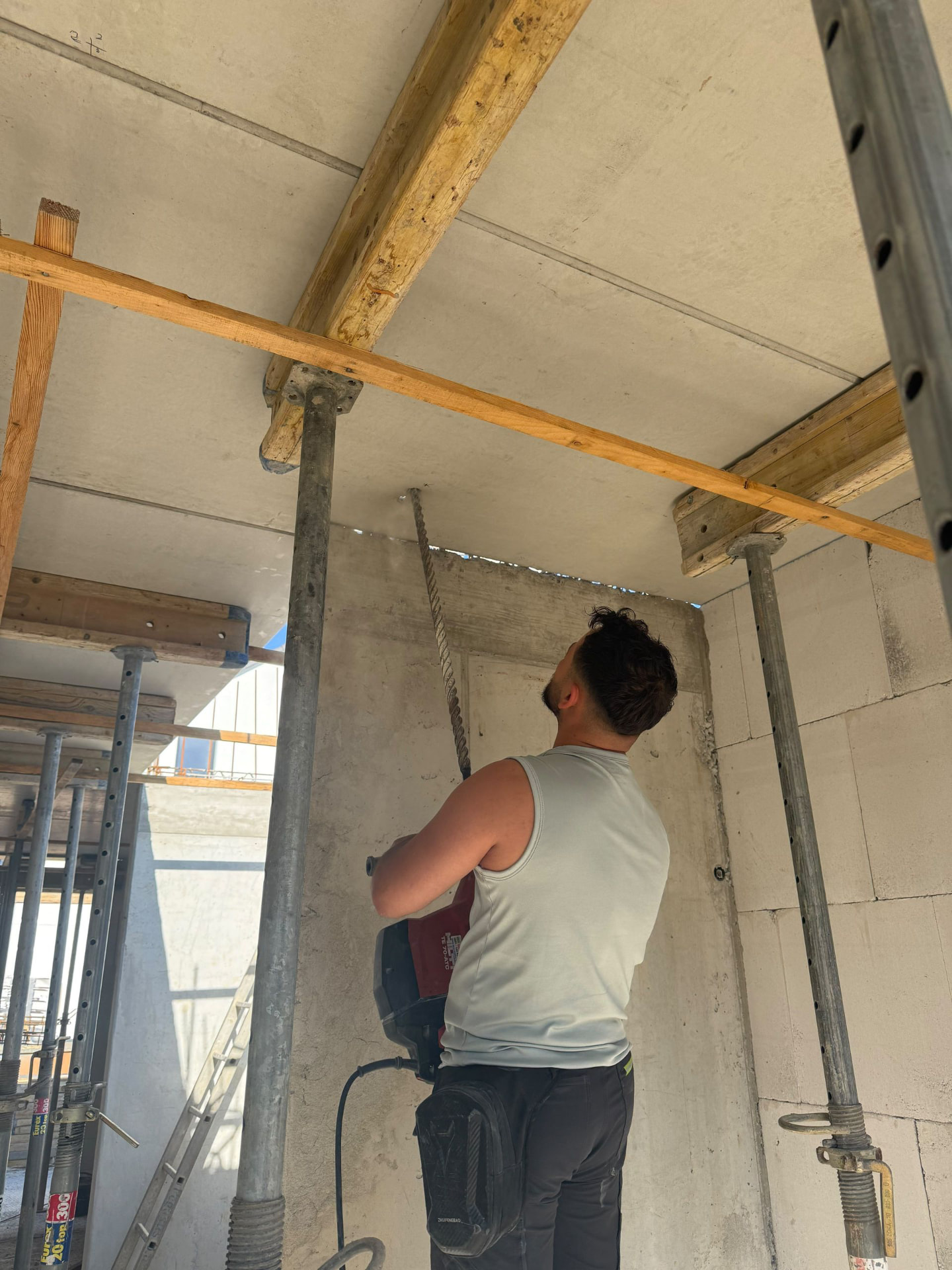 Monteur bei einer Deckenbohrung auf einer Baustelle